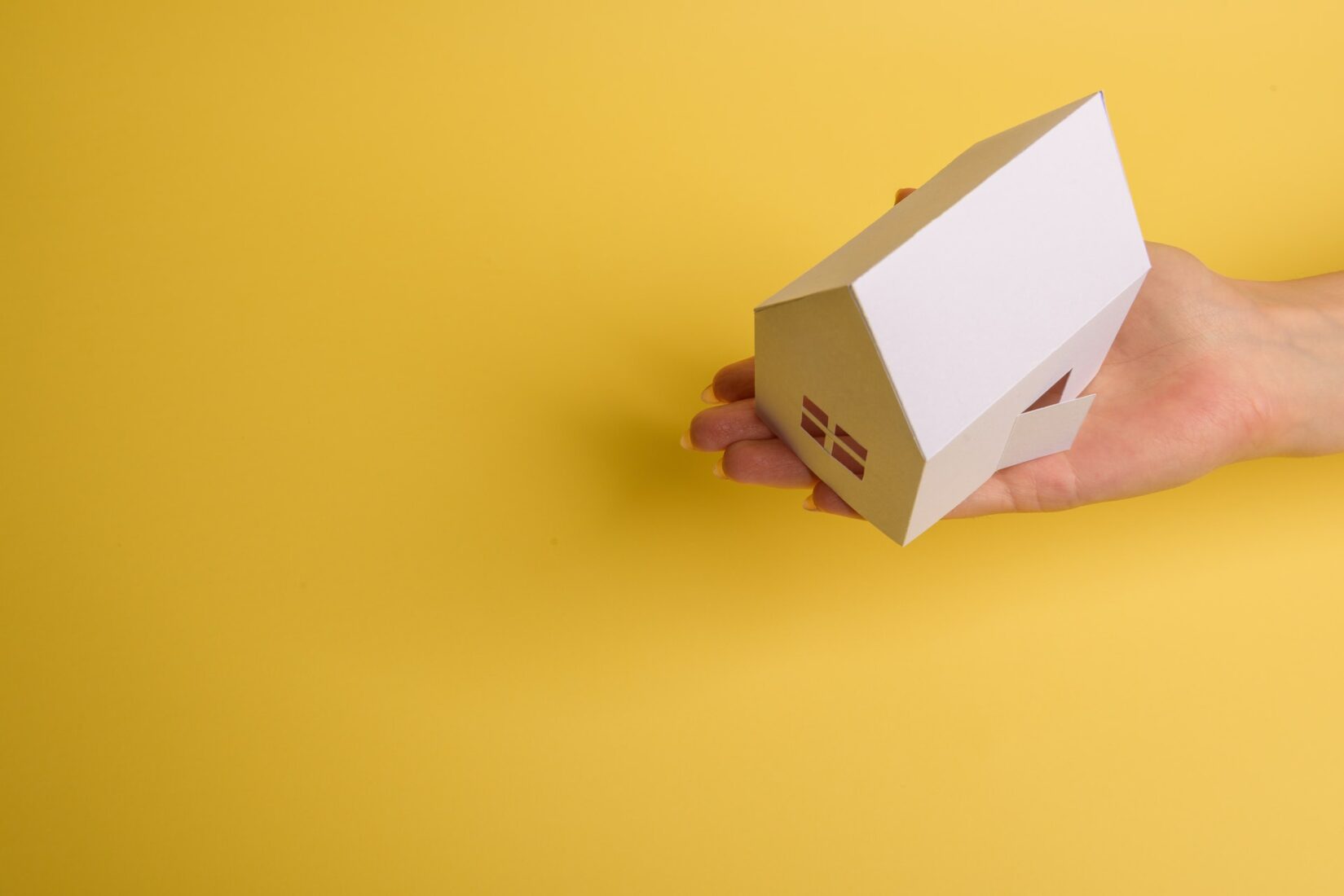 Hand holding a paper house