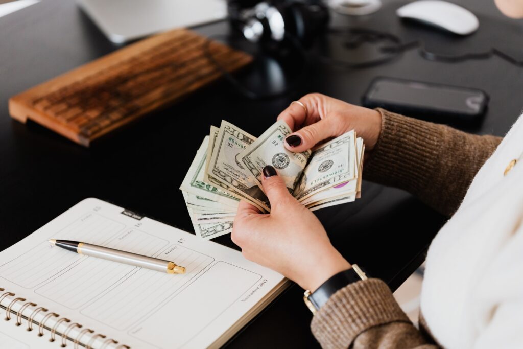 Woman counting money at office table