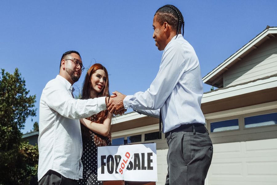 Realtor shaking hands with new home owners