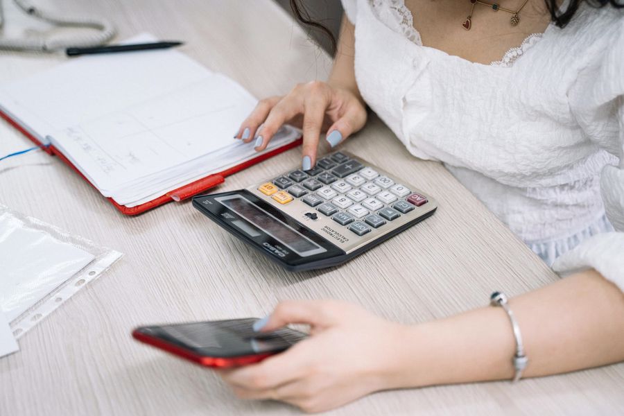 Woman using her calculator to calculate her realtor commission