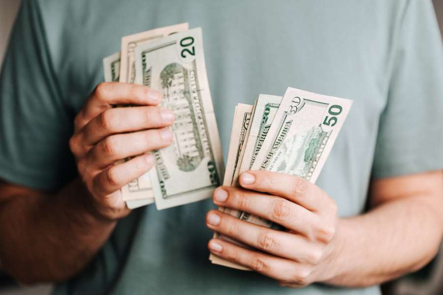 Man counting dollar bills and closing costs