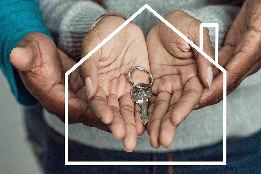 Two people holding a house key on their hands