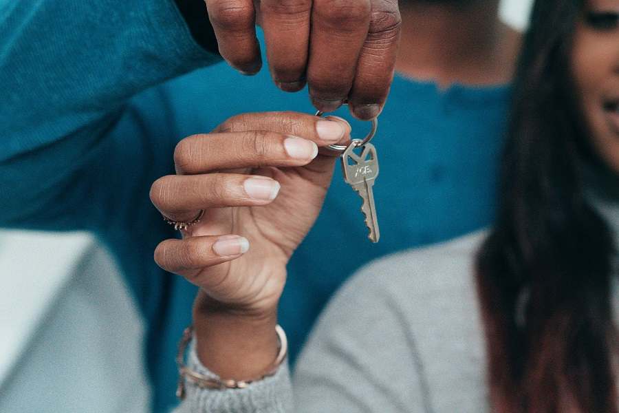 Two people holding a house key