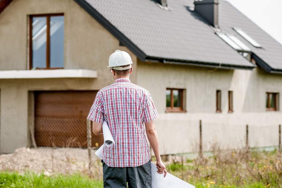 A contractor looking at an unfinished house construction