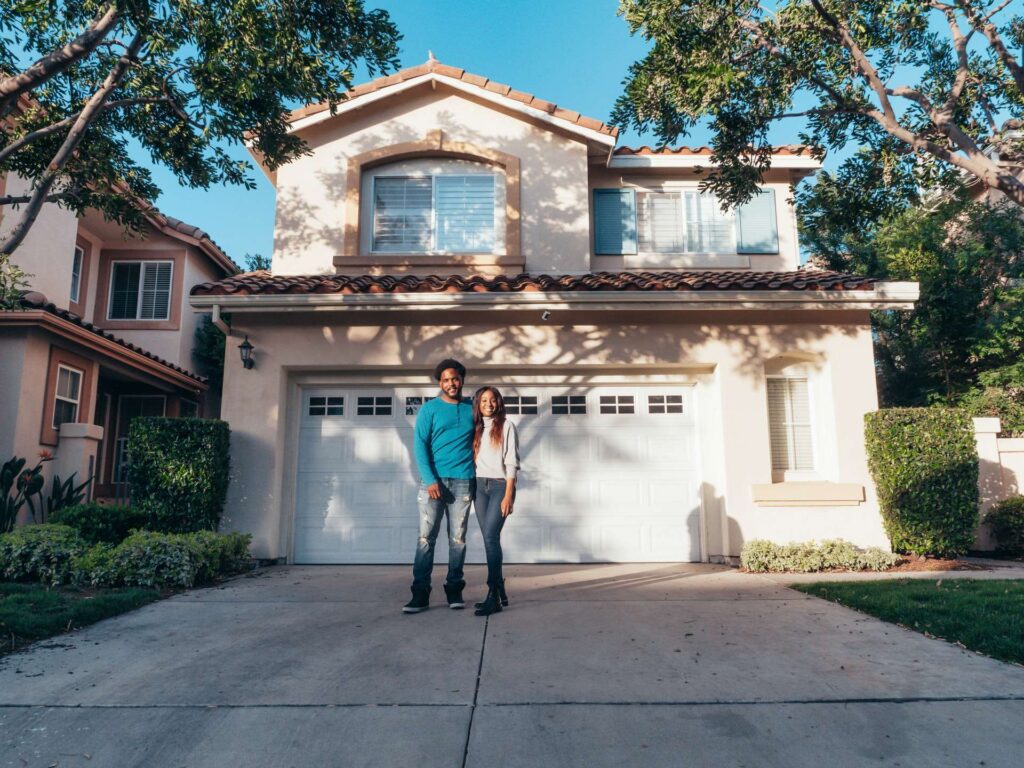 A couple standing in front of their home after buying a house in Arizona