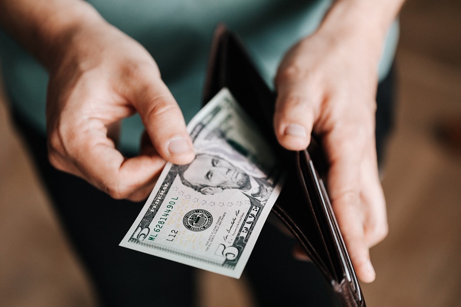 Person pulling out a bill from a wallet