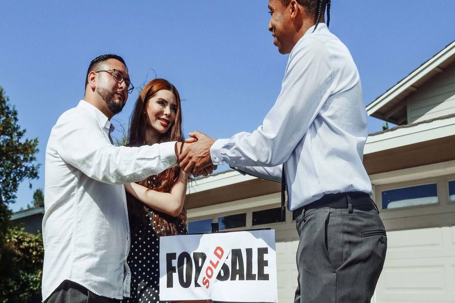 Real estate agent congratulating a couple for closing on a new home