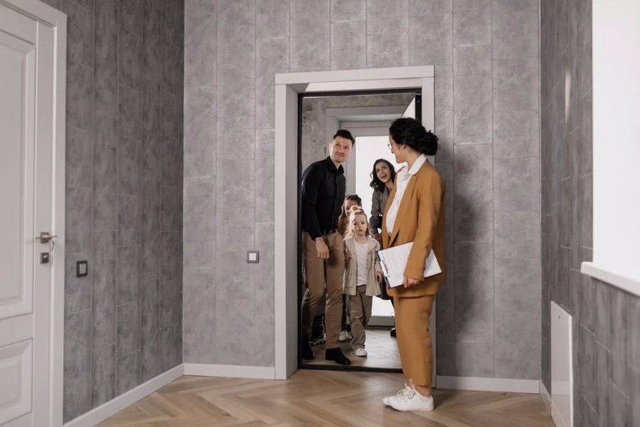 Family inspecting their new home with a real estate agent