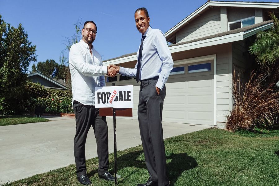 Client shaking hands with an agent after buying a home