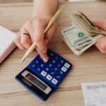Woman calculating money and receipts using her blue calculator