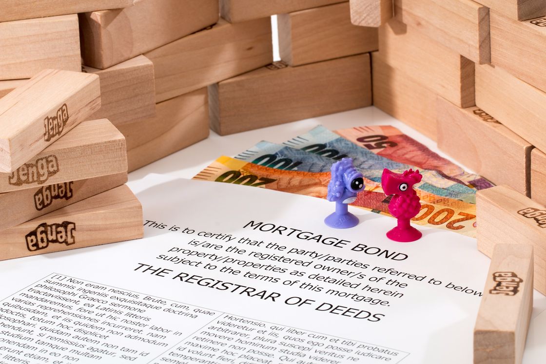 Decorative pins on top of a paper that says "mortgage bonds" and with jenga blocks all around it